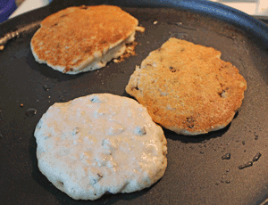 Crumpets cooking in non-stick pan with minimal oil